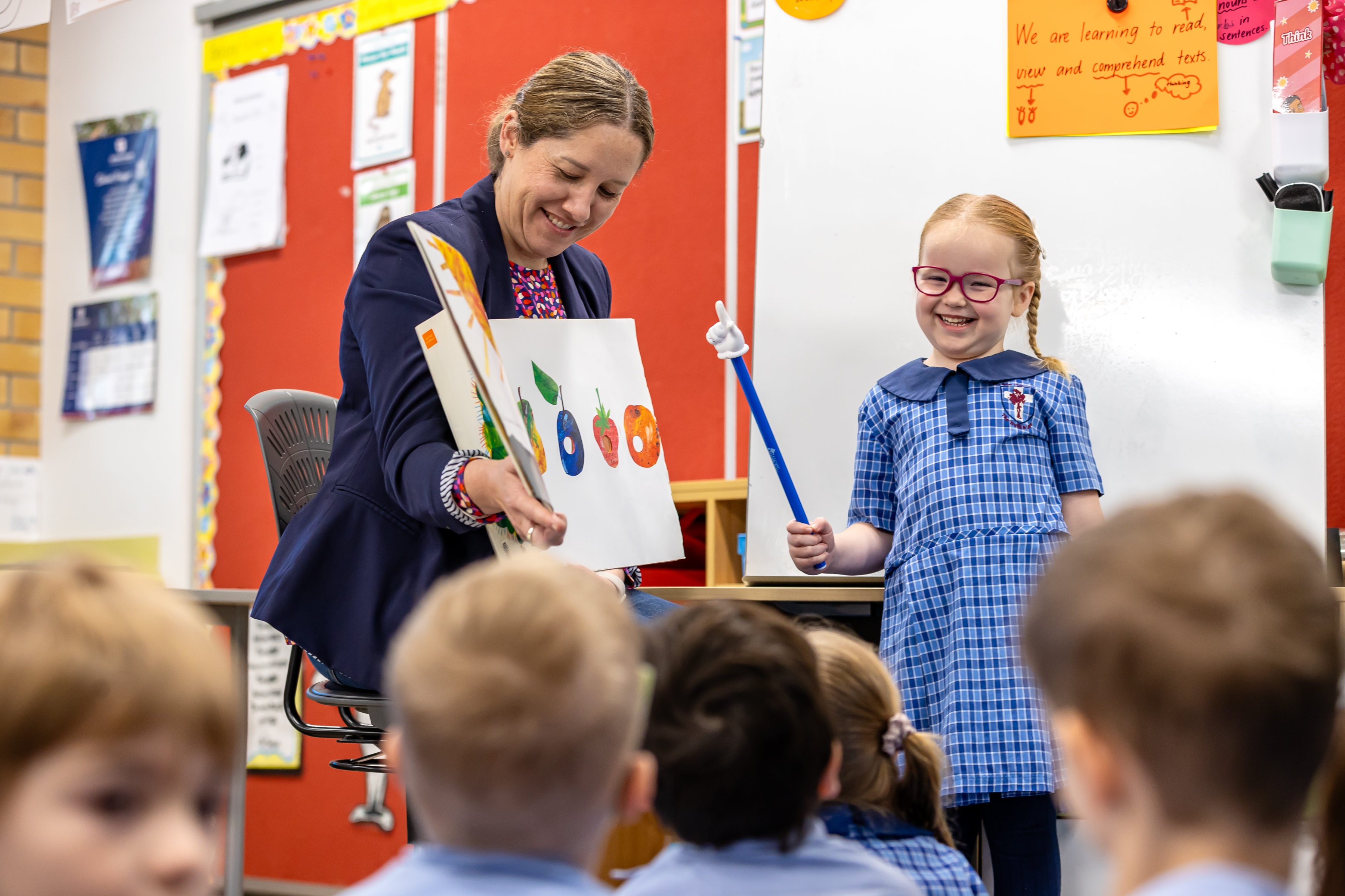 Teacher supporting Prep students during a classroom learning activity, highlighting early years learning, confidence and a supportive classroom environment