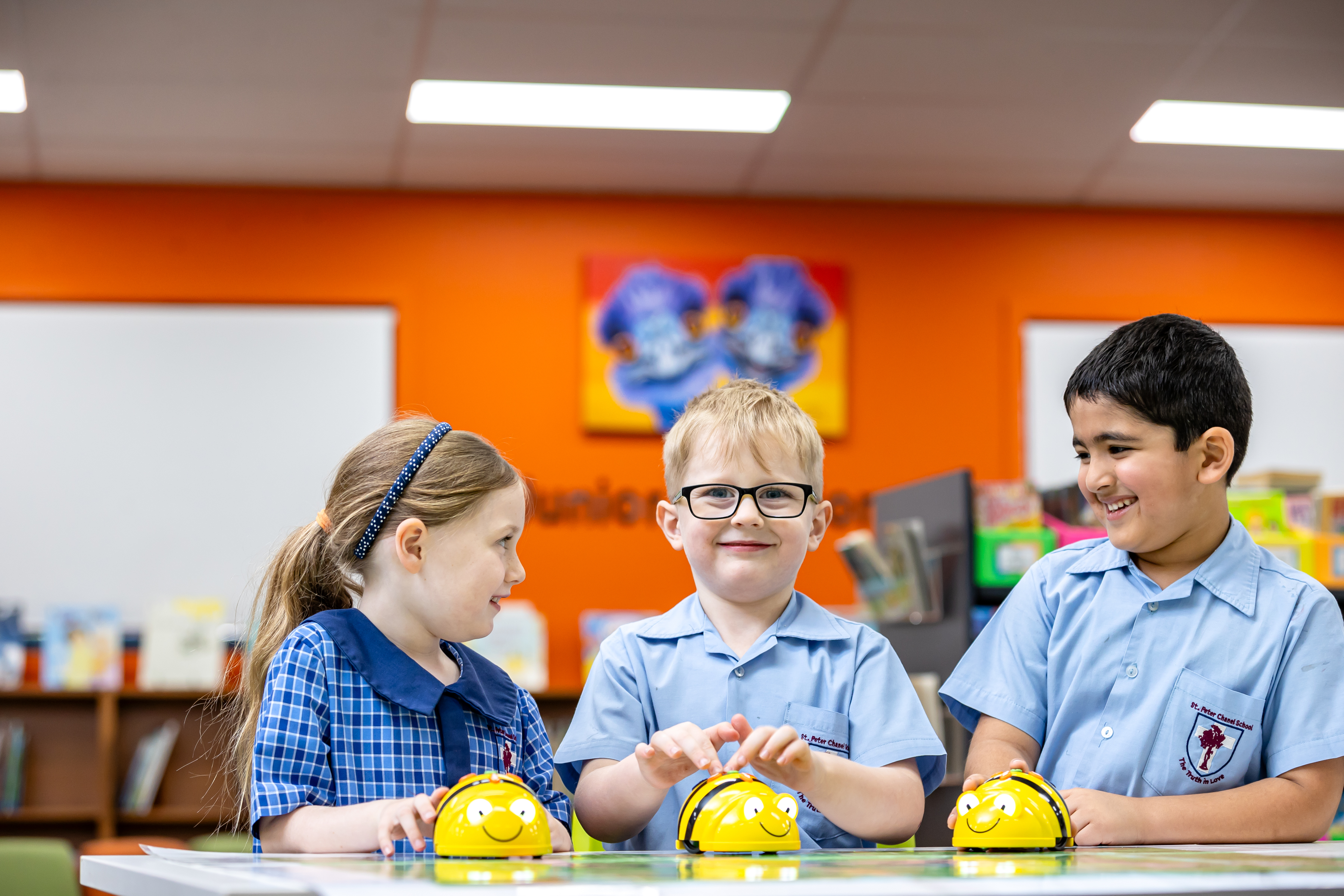 Students using programmable robots together in a learning space, highlighting collaborative STEM learning, problem solving and early coding experiences within the primary school environment