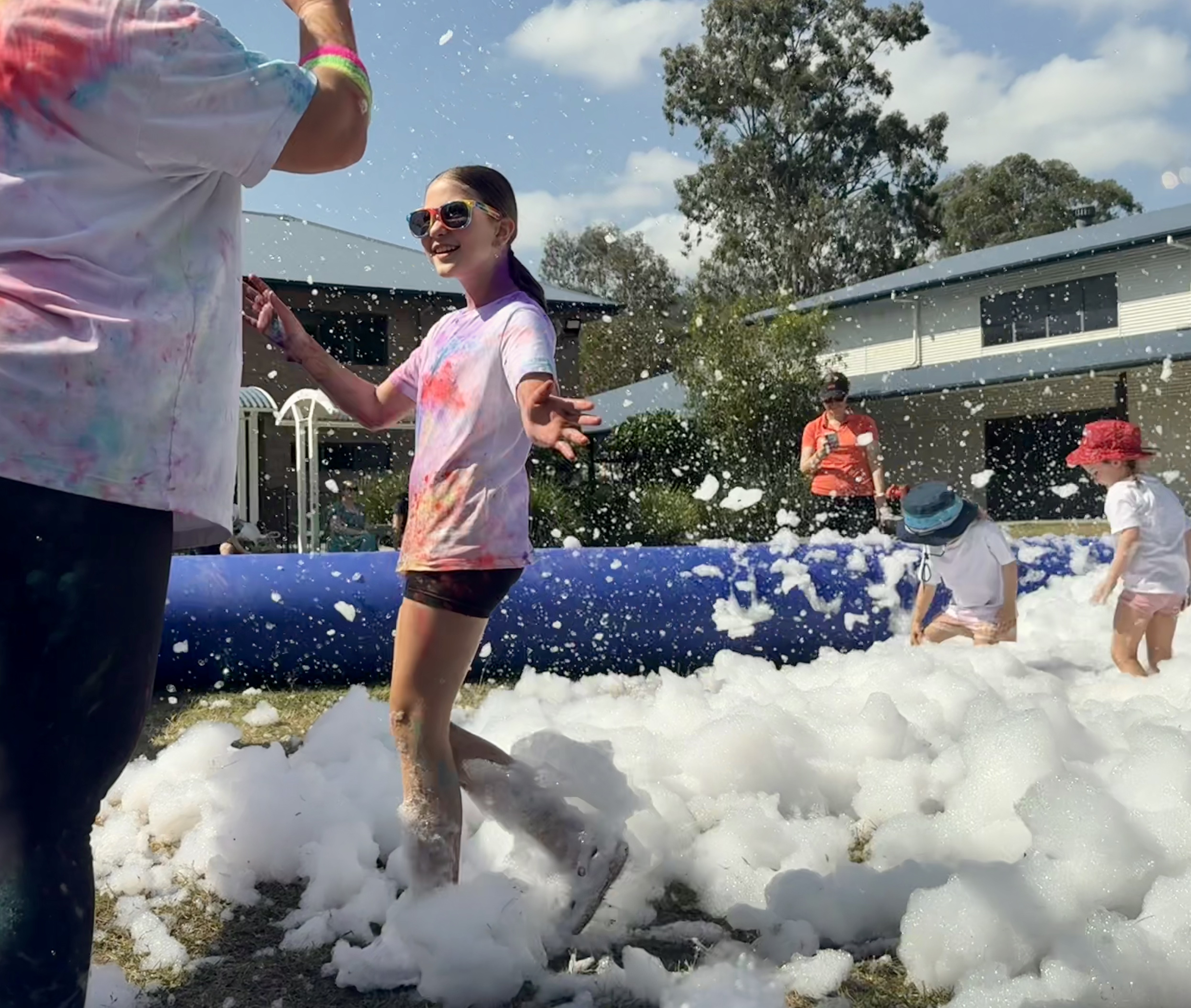 Student moving through foam during the Colour Run, highlighting fun, participation and community celebration at a school fundraising event