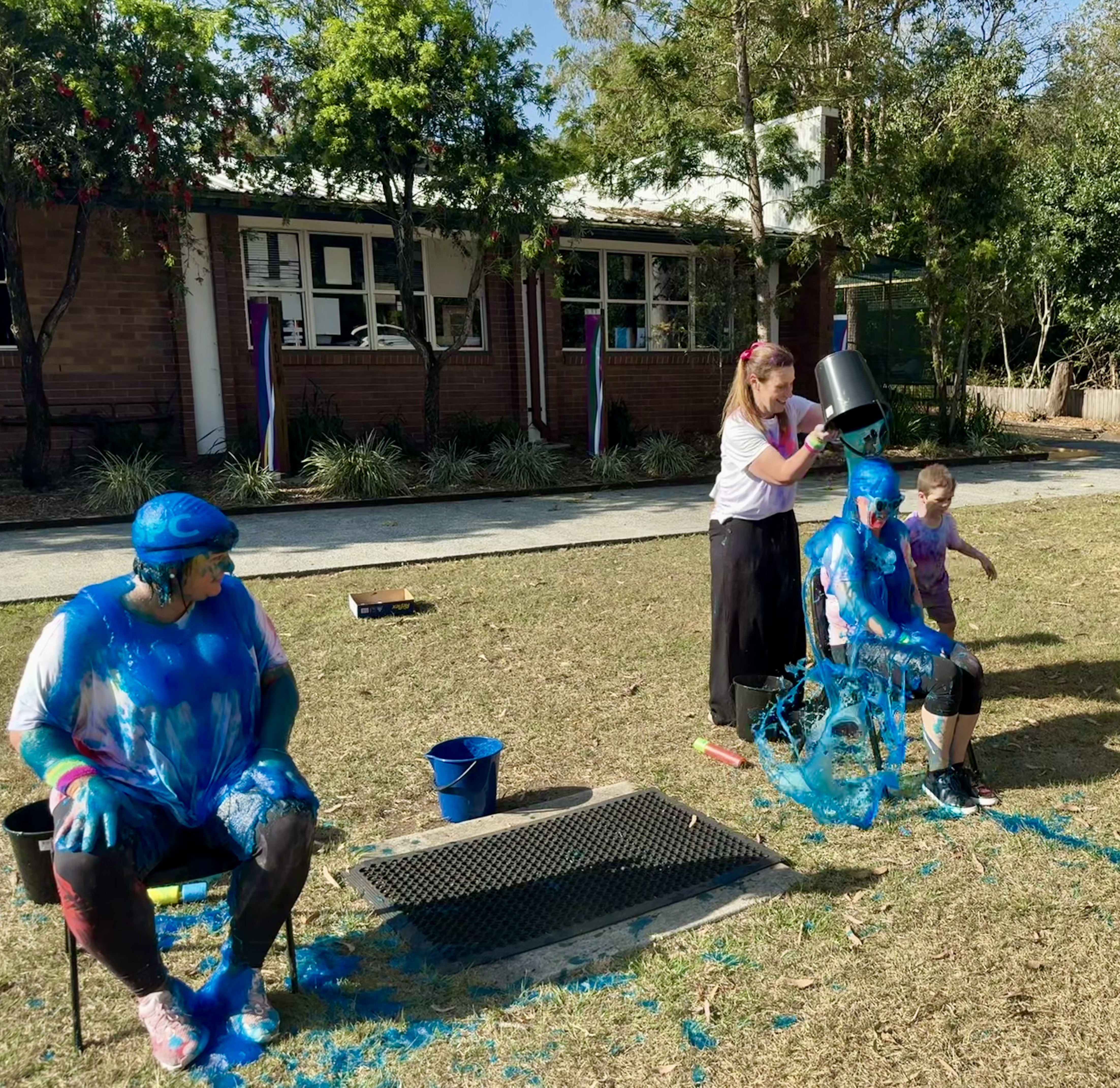 Staff and students taking part in colour and slime activities on the school oval, highlighting fundraising, fun and whole‑school engagement