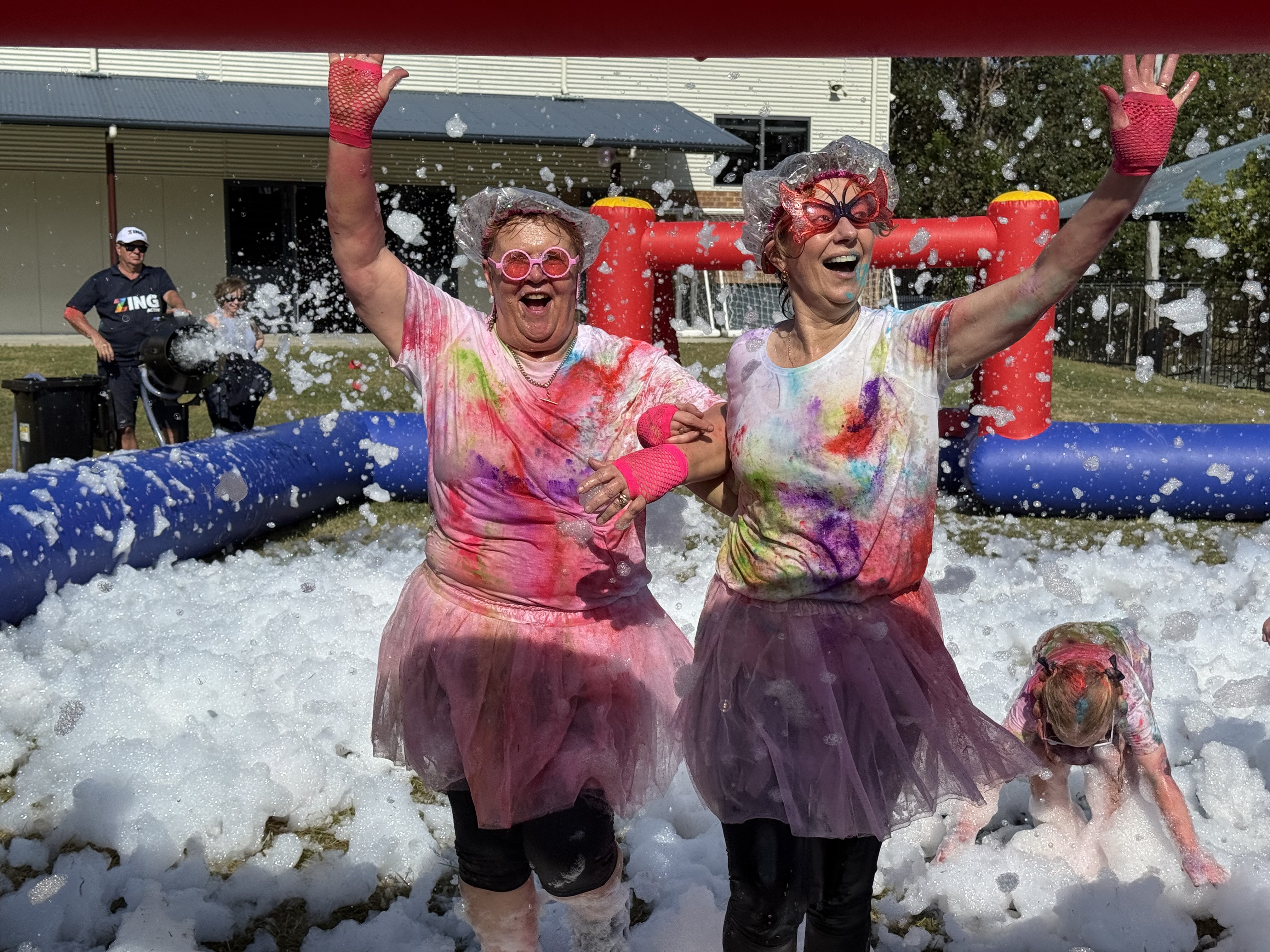 Staff members covered in colour and foam during the Colour Run, highlighting shared joy, staff involvement and school community spirit