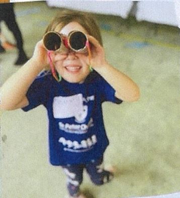 Child engaging in imaginative play using handmade binoculars, highlighting curiosity, creativity and learning through play